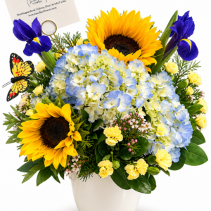 A Little Sunshine floral arrangement featuring yellow sunflowers, blue hydrangeas, purple irises, and seasonal blooms with a butterfly accent in a white ceramic vase by Sassafraz Flowers, Galena, Ohio.