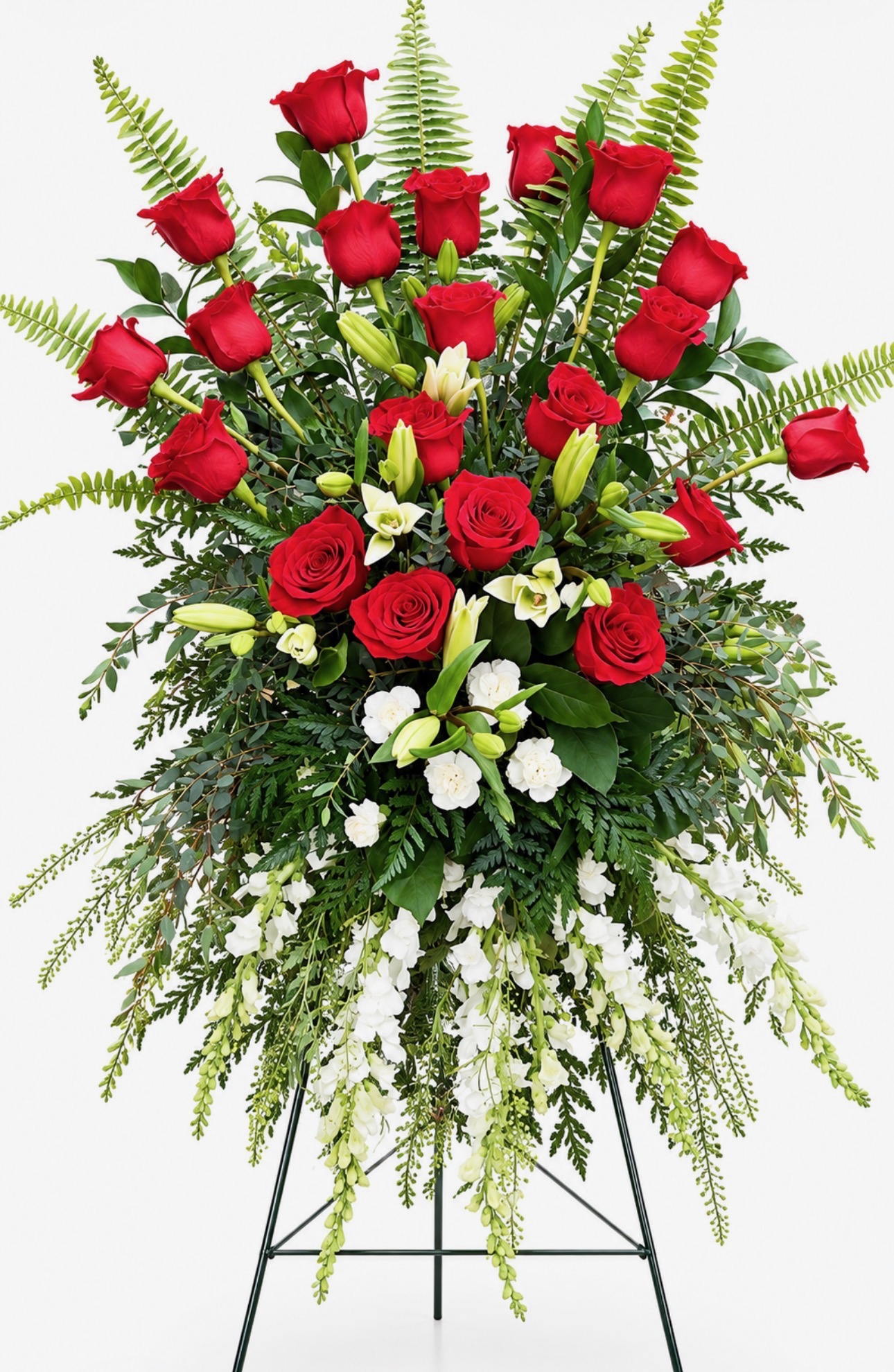 Enduring Devotion standing funeral spray featuring red roses, cascading white flowers, and lush greenery on an easel by Sassafraz Flowers, Galena, Ohio.